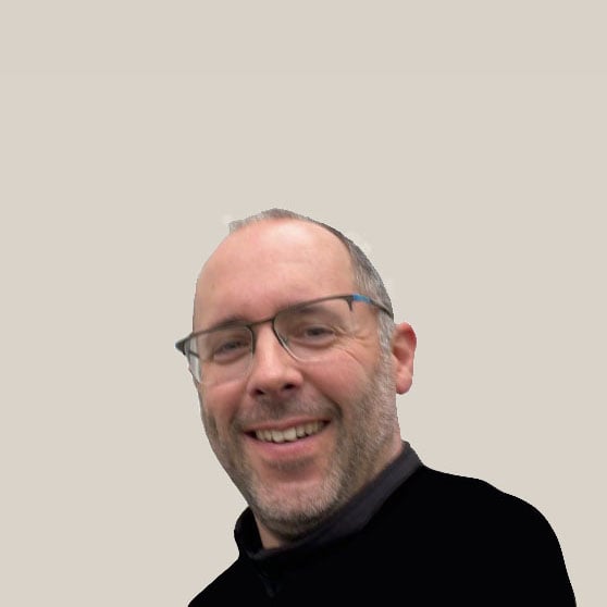 Comfortica werknemer Peter Jansen. Een man van middelbare leeftijd met zeer kort grijs haar en dito baard. Hij staat lachend op de foto en draagt een bril met donkergrijs montuur dat langs de glazen halverwege stopt.