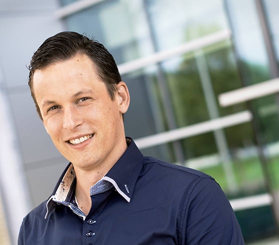 Sean Schuurman van Rouwendal van Comfortica. Smal lachend gezicht, donker kort haar en donkerblauw overhemd.
