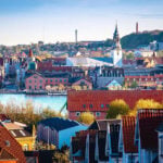 Stadsgezicht op haven en centrum van Aalborg in Denemarken. Blauwe lucht, rode daken. Deel van het EU project INBLANC duurzaam wonen en werken waaraan Comfortica deelneemt.
