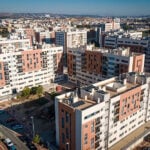 Joven Futura buurt in Spanje. Je ziet tal van heel licht steen-oranje appartementencomplexen met grote donkerder steen-oranje vlakken. Op de achtergrond heuvels en een strakblauwe lucht. Deel van het EU project INBLANC duurzaam wonen en werken waaraan Comfortica deelneemt.
